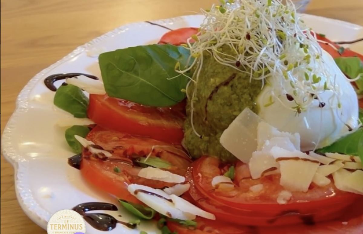 Tomates, burrata et pesto sur table de chêne