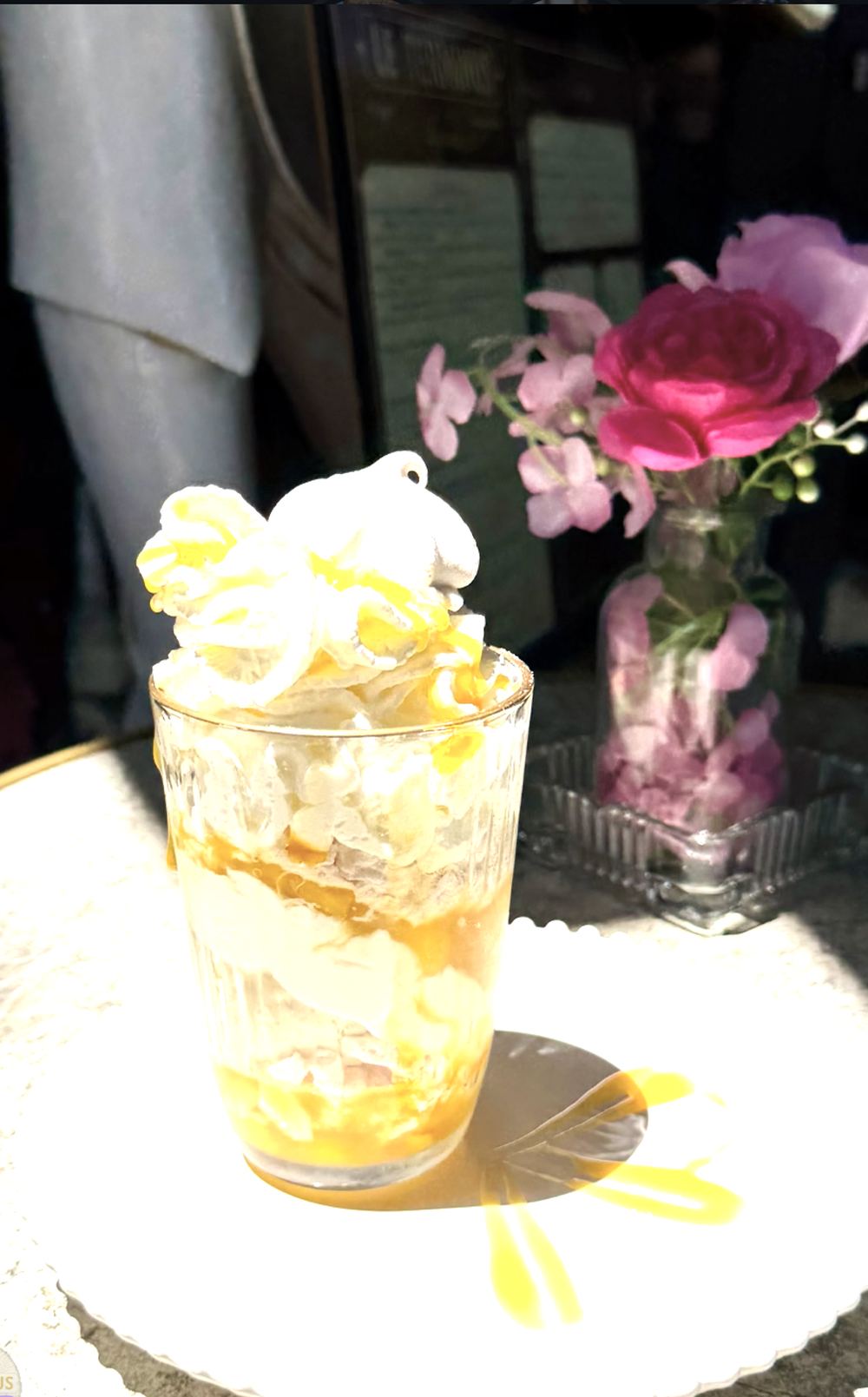 Coupe glacée et roses fraîches sur un guéridon