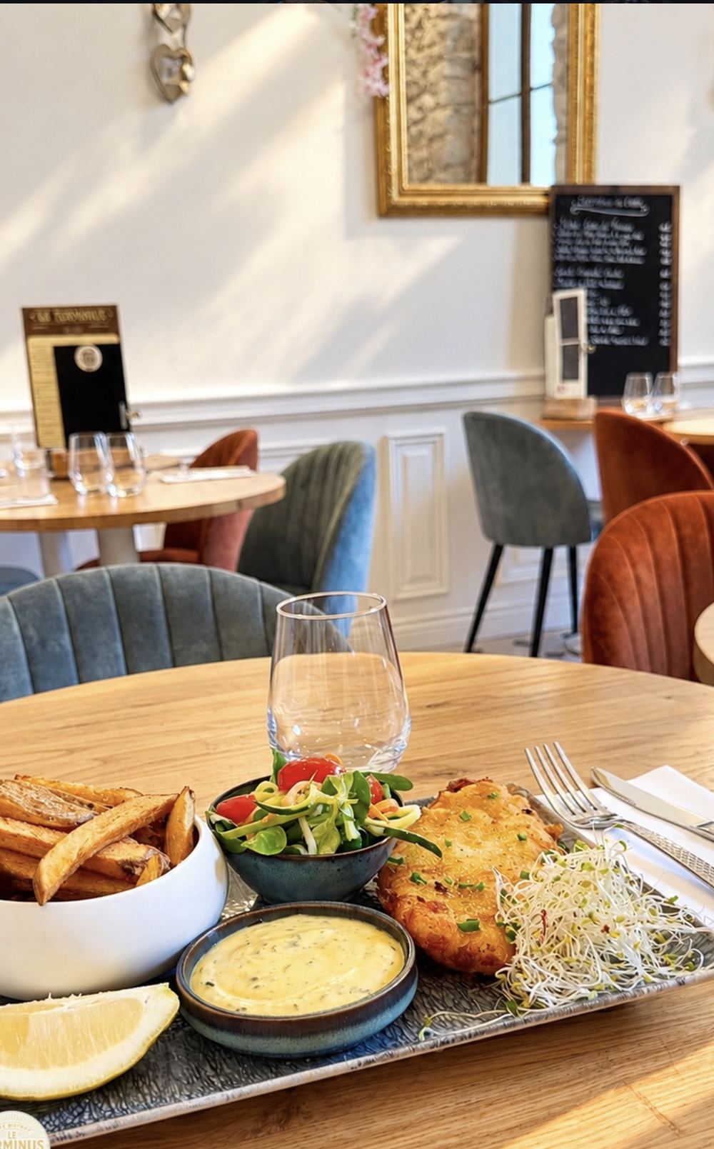 Une assiette servie en salle, boiseries crème et velours